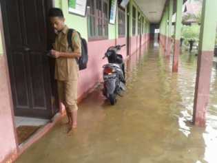 Di Guyur Hujan, Puluhan Siswa Laksanakan UN di Atas Banjir